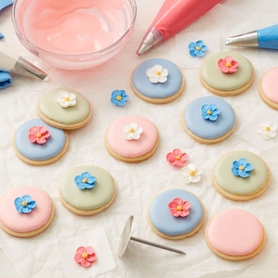 Biscoitos decorados com glacê colorido e pequenas flores de glacê