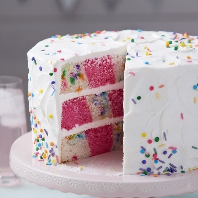 Bolo de aniversário colorido com creme branco e granulados coloridos