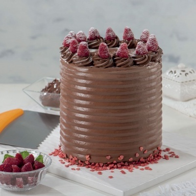 Bolo de chocolate alto com framboesas e decoração em açúcar