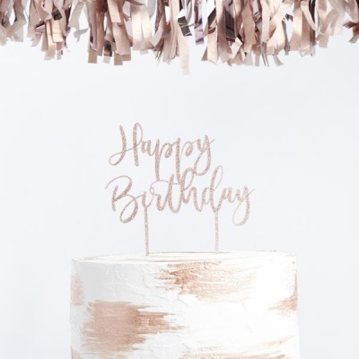 Bolo branco com detalhes dourados e topo com texto 'Happy Birthday' dourado.