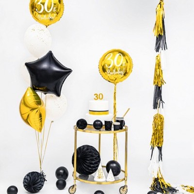 Decoração de festa com balões dourados, pretos e brancos e mesa com bolo 30 anos