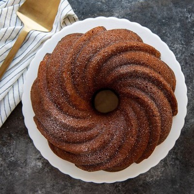 Bolo bundt com padrão espiral e textura granulada num prato branco