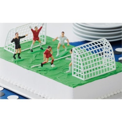 Bolo decorado com tema de futebol e miniaturas de jogadores e balizas.