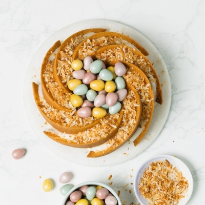 Bolo decorado com fios de ovos, coco ralado e ovos de chocolate coloridos