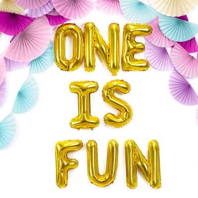 Balões dourados letra a letra a dizer ONE IS FUN com leques de papel coloridos ao fundo