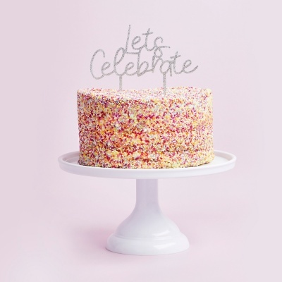 Bolo decorado com granulados coloridos e topper prateado numa base branca