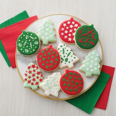 Biscoitos decorados temáticos de Natal num prato branco com borda dourada