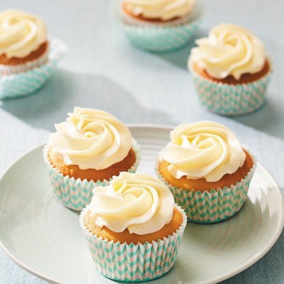 Cupcakes com cobertura de creme em forminhas azul e branco em prato
