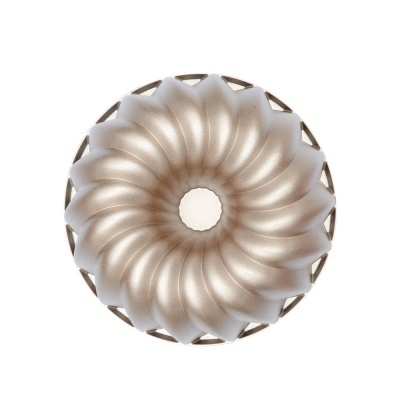 Forma de bolo prateada com textura ondulada em espiral sobre fundo branco