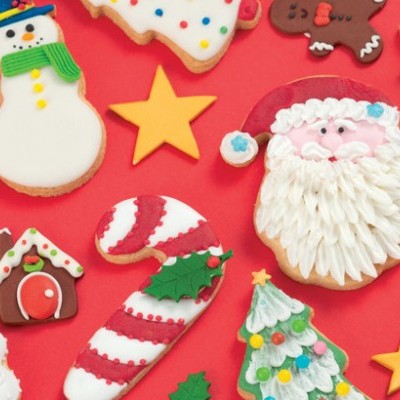 Bolachas de Natal decoradas com glacê colorido sobre fundo vermelho