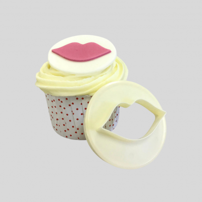 Cupcake decorado com creme e cortador de plástico em forma de lábios