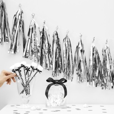 Decoração com balões de morcego pretos, frasco com laço preto de bolinhas brancas e guirlanda metálica prateada