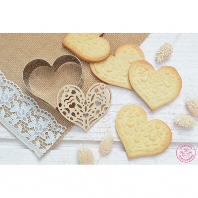 Biscoitos em forma de coração com cortador e recorte de madeira, sobre tecido de renda