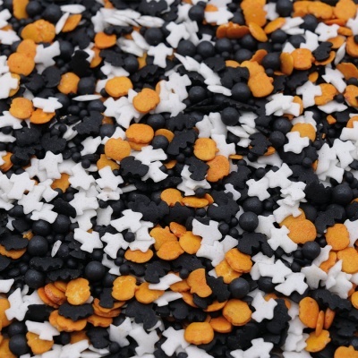 Confeites açucarados em forma de caveira laranja, branco e preto