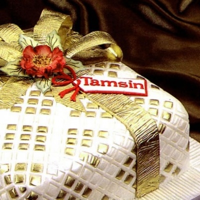 Bolo decorado branco e dourado com fita e flor vermelha