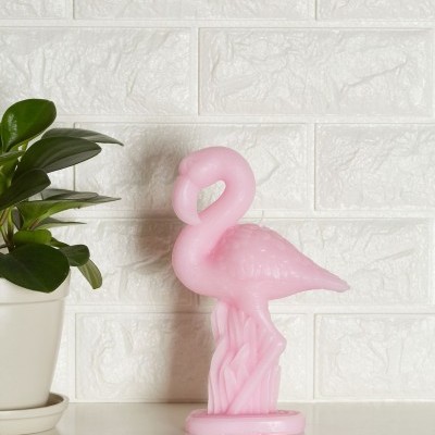 Figura de flamingo cor-de-rosa decorativa ao lado de vaso com planta