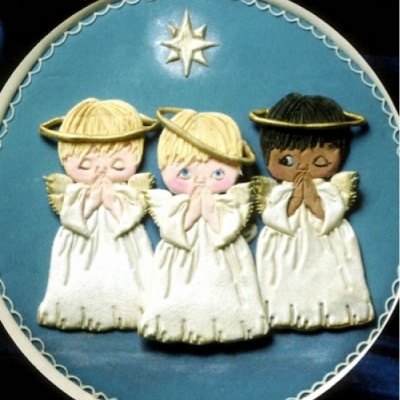 Placa redonda azul com três anjinhos brancos em cerâmica, dois loiros e um negro, com auréolas e estrela dourada.