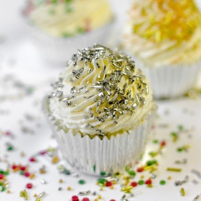 Cupcake com cobertura branca e granulados prateados em embalagem metálica prateada