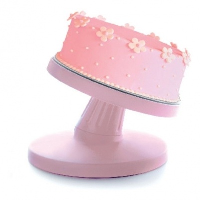 Bolo rosa decorado com flores em suporte giratório rosa.