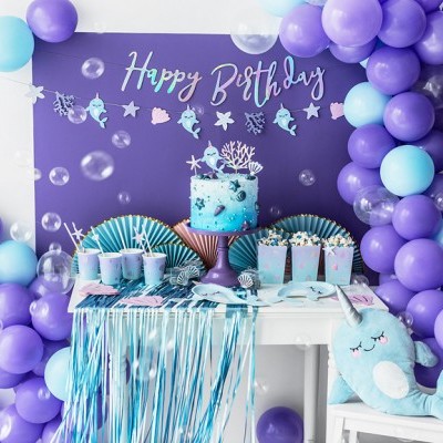Decoração de festa de aniversário com balões azuis e roxos, bolo marinho azul e painel 'Happy Birthday'