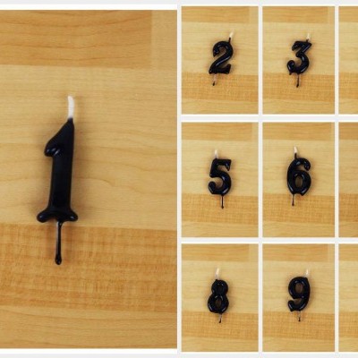 Velas números pretos de 0 a 9 numa superfície de madeira