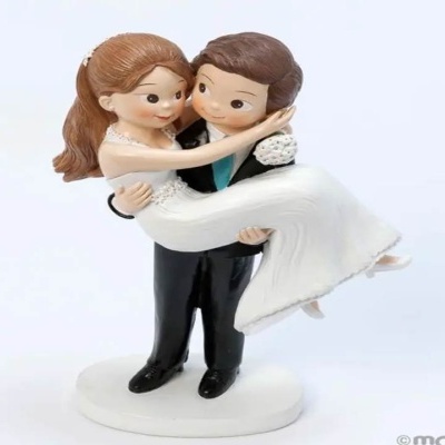 Estatueta de casal de noivos com noivo a segurar a noiva