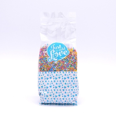 Saco transparente com confeitos coloridos e etiqueta 'Just add Love'