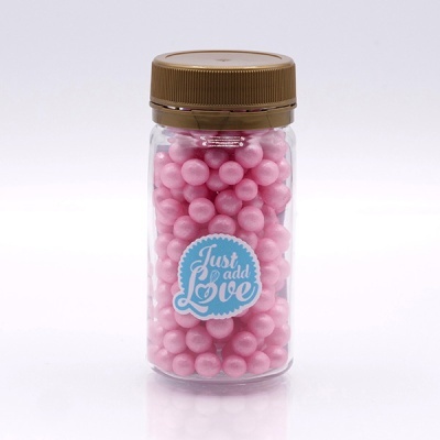 Frasco com bolas cor-de-rosa e etiqueta azul 'Just add Love'