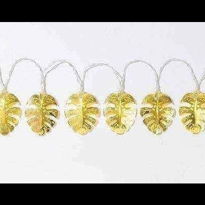 Folhas douradas em fio branco alinhadas