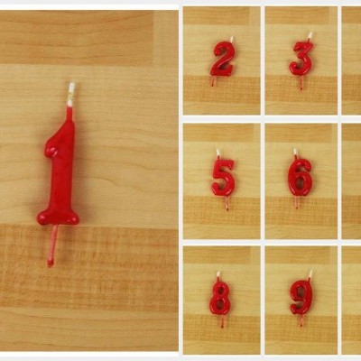 Velas numéricas vermelhas em superfície de madeira clara