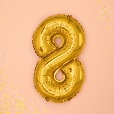 Balão dourado em forma de número 8 com confetes amarelos num fundo cor de salmão