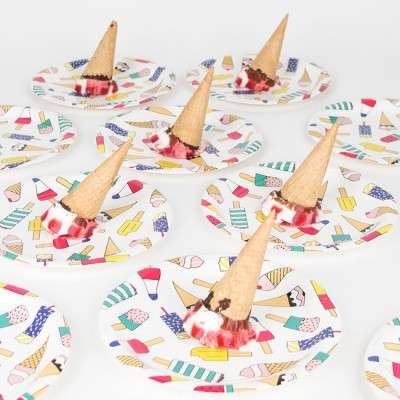 Cones de gelado virados com gelado derretido dispostos em pratos coloridos com padrões de gelados