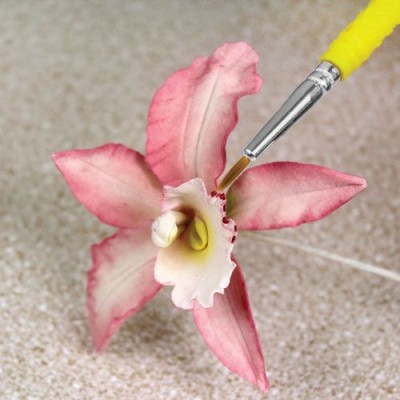 Flor artificial rosa com pincel amarelo pintando-a