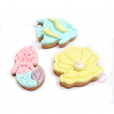 Bolachas decoradas com glacê em forma de sereia, peixe e concha