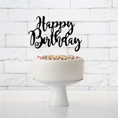Bolo branco decorado com confeitos coloridos e um topo de bolo com as palavras Happy Birthday