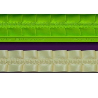 Duas fitas decorativas, verde fluorescente e creme, com textura ondulada e rendada sobre fundo roxo