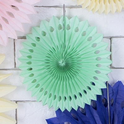 Fachas decorativas de papel coloridas penduradas numa parede branca