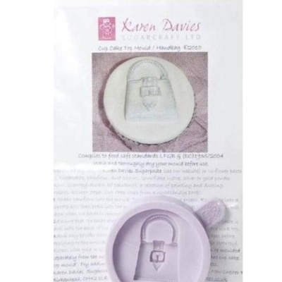 Molde de silicone lilás para bolo em forma de mala de mão sobre embalagem com imagem e texto.