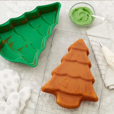 Forma silicone verde árvore de Natal com bolo assado e creme verde ao lado