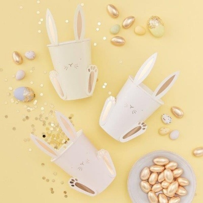 Três cestos de coelho com ovos decorativos dourados e coloridos em fundo amarelo