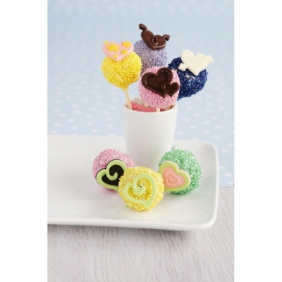 Bolos coloridos com decoração de chocolate em chávena e prato brancos.