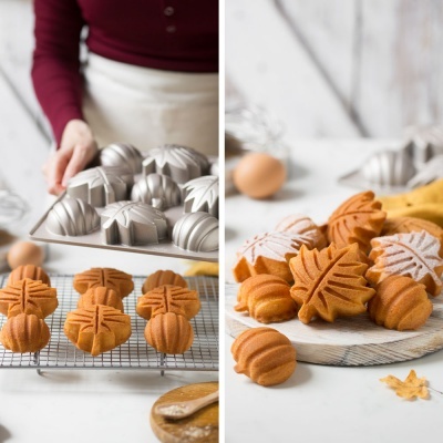 Formas metálicas para bolos e bolos em forma de folhas e abóboras em bancada