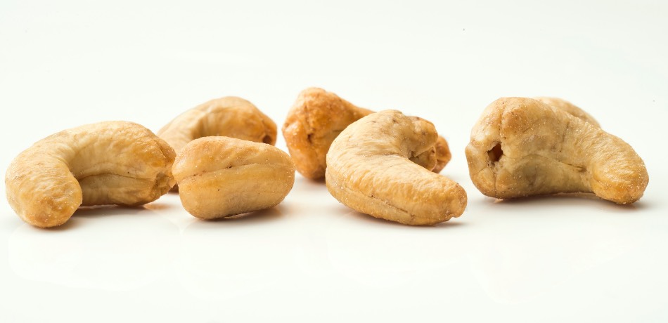 Cinco anacardos castanhos claros sobre fundo branco