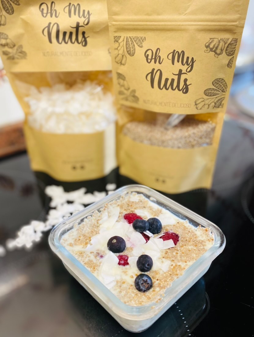 Sobremesa com frutos vermelhos e mirtilos à frente de embalagens Oh My Nuts
