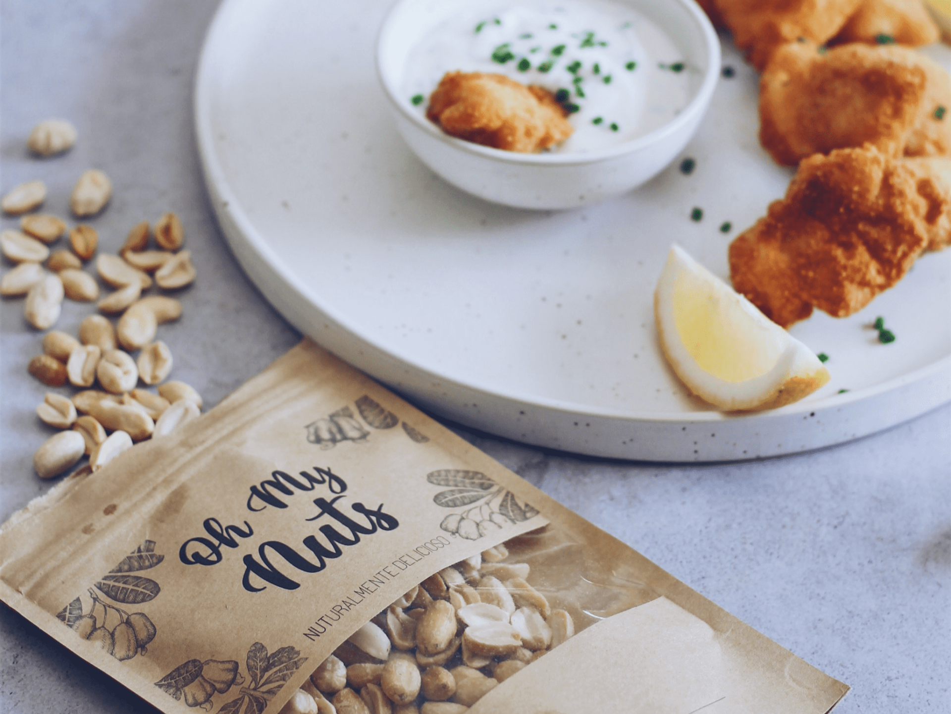 Pacote de nozes, amendoins e comida crocante num prato branco