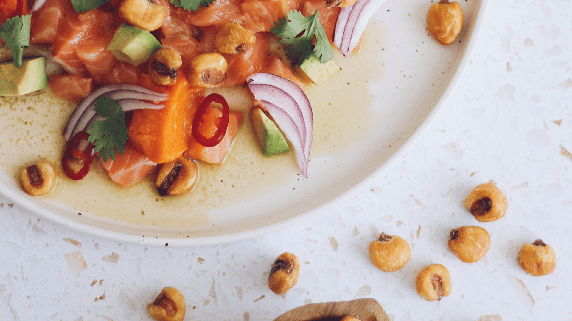 Salada de salmão cru com abacate, cebola roxa, coentros e malagueta em prato branco
