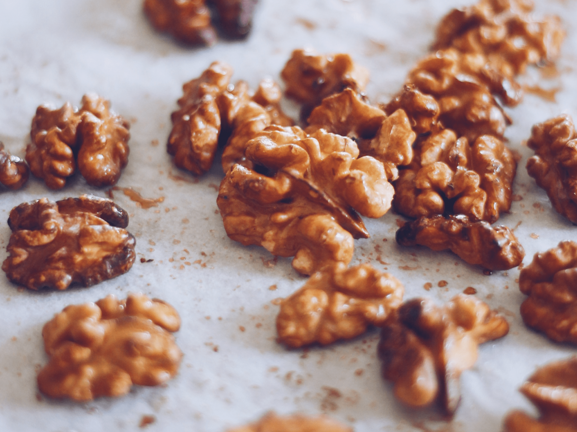 Nozes descascadas espalhadas sobre papel branco