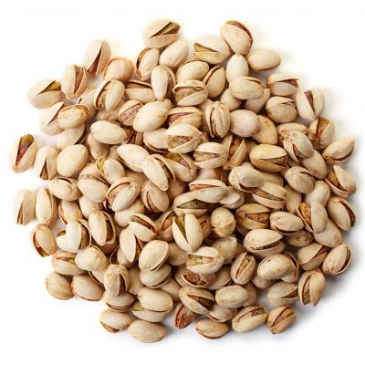 Pistáchios com casca clara e parcialmente abertos sobre fundo branco