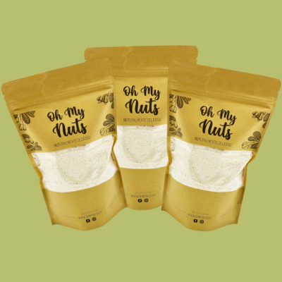 Três embalagens de stand-up pouch castanho claro com texto Oh My Nuts e ilustrações de nozes