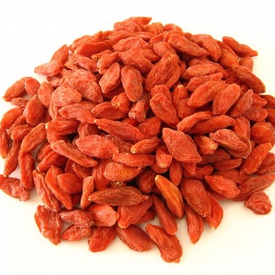 Montão de bagas de goji secas vermelhas num fundo branco